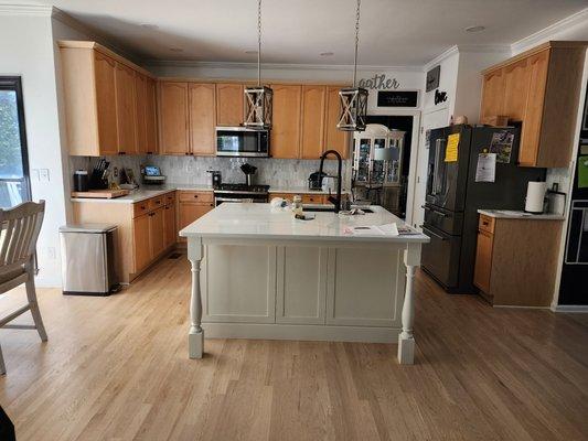 Custom island, pendant lights installation, quartz countertops, and backsplash.