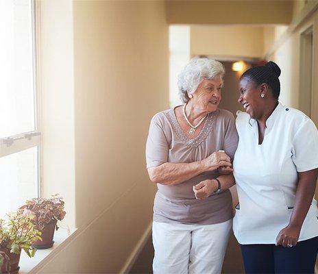 A PCA assist a citizen senior on a walk.