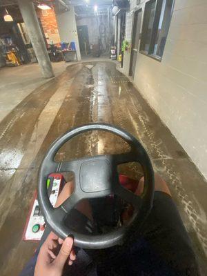 Automatic ride on scrubber cleaning a concrete floor.