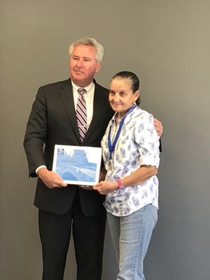 Best of Care Home Health Aide - Maria - being recognized for her excellence by State Representative Bruce Ayers of Quincy