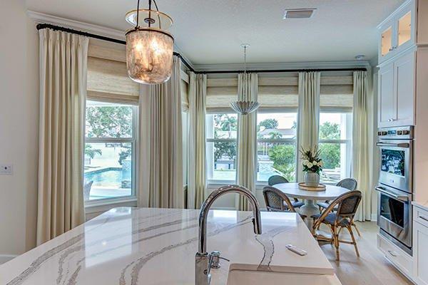 Draperies and woven wood shades are the perfect combination to elevate this kitchen dining combination