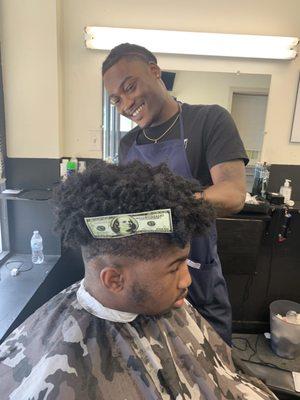 Elizjah the newest barber at Headliners doing his thing (money clip holding up the hair for a shape up).