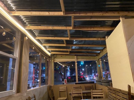 Heated outdoor seating- large space with beautiful wooden tables and cute lighting