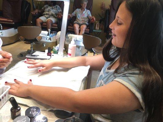 Happy girl getting her nails done.