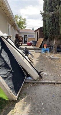 Before photo of outside rubbish, deck and shed before demo