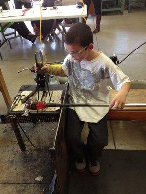 A young person taking a glass lesson at Ferguson Gallery.