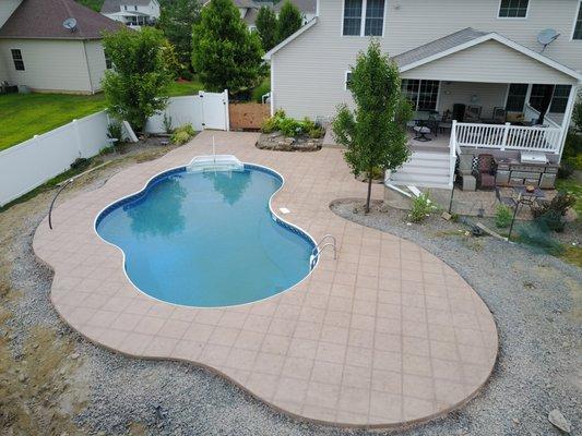 Stamped concrete around pool with decorative cut