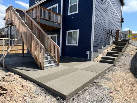 New build backyard with concrete patio and steps