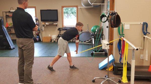 Chris Kersten, DPT helping young baseball player with arm care - using Blood Flow Restriction Therapy.