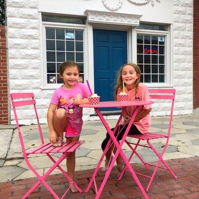 Two kids enjoying some yogurt out front of our new building