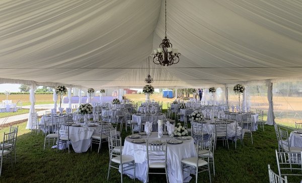 Reserve a tent today! Shown here with liner, leg drapes, bronze chandeliers, and right side clear sidewall!