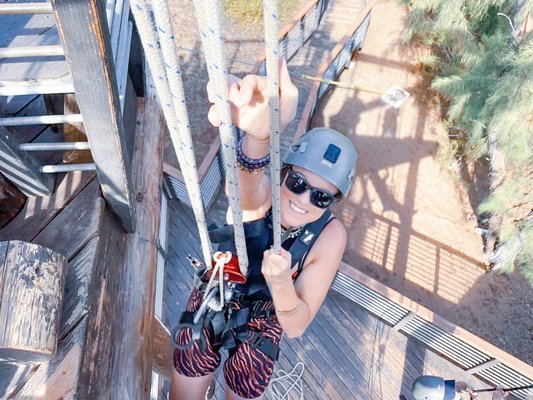 Climbing one of the challenges in between the zip-lining.