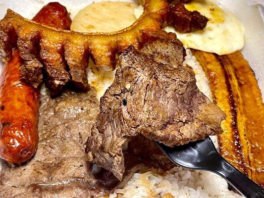 Bandeja Paisa - steak, fried egg, Colombian sausage, chiccaron, mini corn cake, sweet plantain, over white rice - takeout