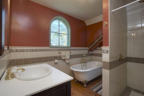 One of 2 1/2 bathrooms on the second floor includes large porcelain soaking tub.