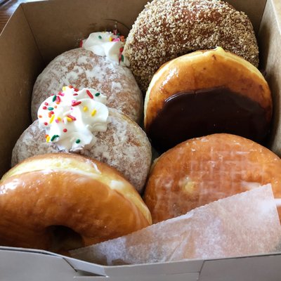 Small box of donuts: vanilla cream, honey glazed, jelly-filled, Boston cream, butternut.