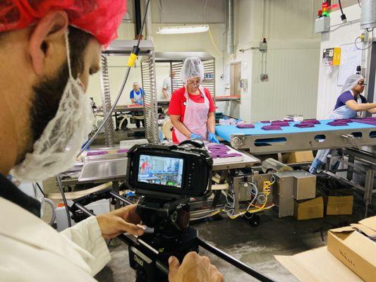 On a location video production shoot at a food manufacturing company capturing footage for a brand identity video.