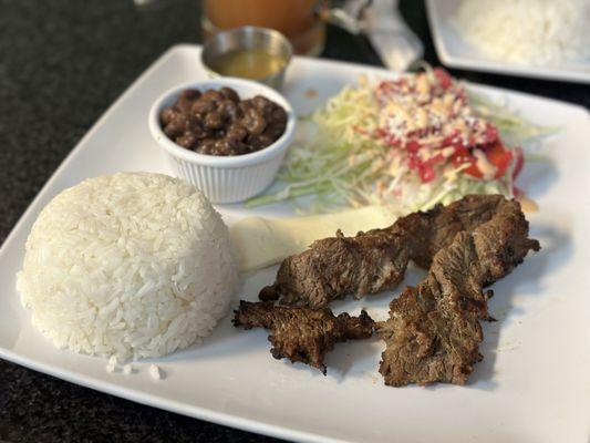 Grilled beef with rice, salad, fried beans and tortillas