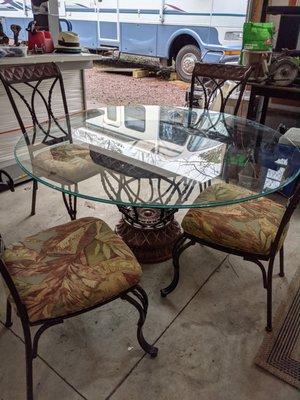 70-in glass top table with beautiful base and six beautiful wrought iron chairs newly upholstered