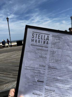 Outdoor seating on the boardwalk and menu.