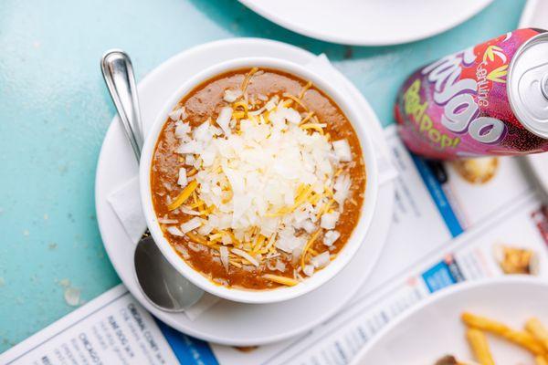 Bowl of our famous chili with onions and shredded cheese.