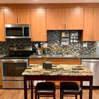 Kitchen with modern SS appliances, dishwasher, microwave, stove and oven. SS dual sink with detachable hose faucet.