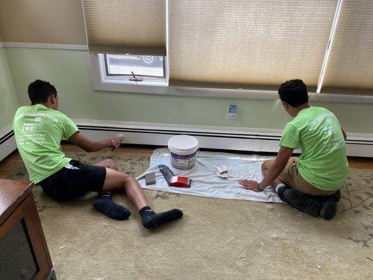 Repainting old dirty brown baseboard a new bright inviting white