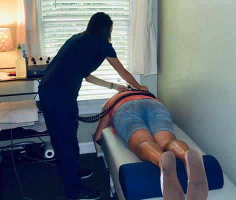 A Chiropractic Assistant applying therapy to a patient.