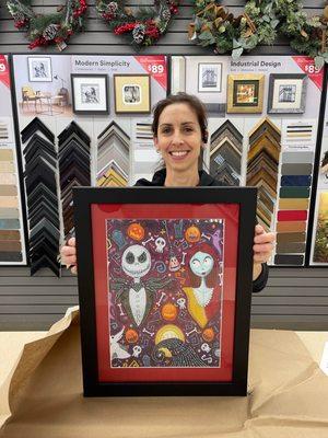 Kelly, professional framer with Michael's in Sparks, holding up the beautifully framed  Jack Skellington piece with red mat. Excellent!