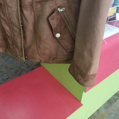 The jacket is darker in the front and the sleeves after being cleaned by Peaches Cleaners.