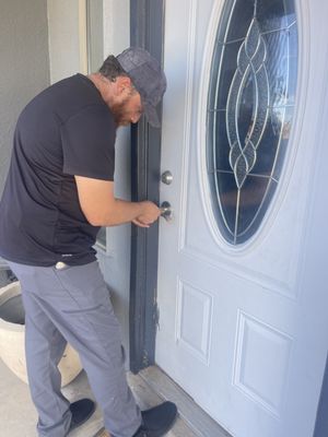 Unlocking front door of a home.