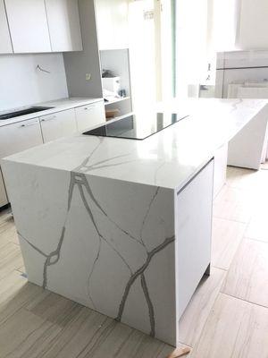 Calacatta Quartz countertop with waterfall edge detail delivers a statement design to this kitchen.