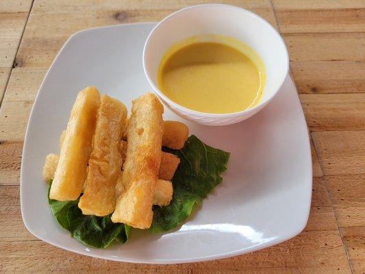 Yuca a la Huancaina - Fried yuca covered with a creamy yellow Peruvian pepper sauce.