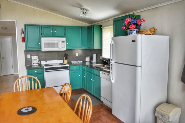 The kitchen inside the dog friendly "deleware unit" stocked with pots, pans, utensils, plates and bowls.