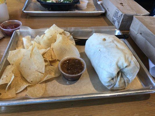 Spicy chicken burrito with fresh chips. The burrito is huge.