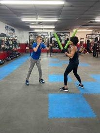 My son getting a quick lesson with Coach Cherry after our fitness class.