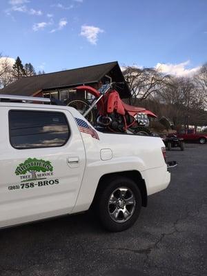 The unorthodox loading of the bike with the front tire on the rear deck of my hard top cover. Works for me.