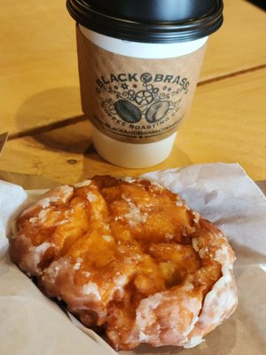 Delicious apple fritter along with really good cup of coffee .