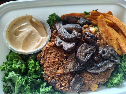 black bean burger with raised mushrooms and roasted sweet potatoes over kale.