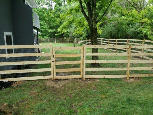 Open wooden fence installed with modern split rail with welded wire allowing animals to see through built by Green Tree Columbus.