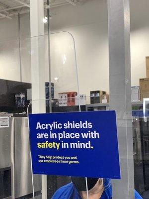 Signage regarding acrylic shield at checkout counter