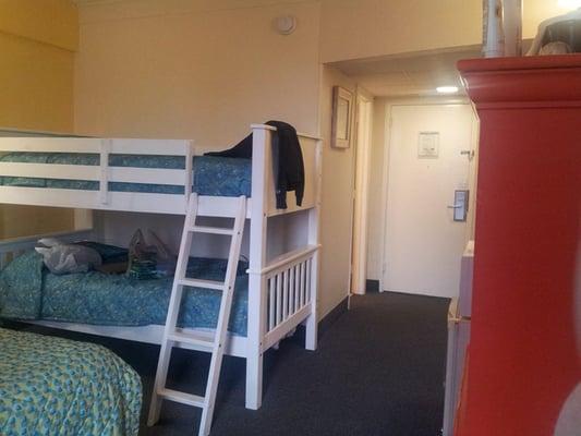 Bed, Bunk beds, bathroom on left, hotel bedroom door