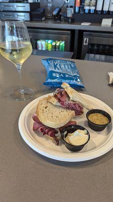 Thick pastrami sandwich,  but meat chilled, not warm. . Chardonnay, bland. Great waitress, handling a full bar with folks, coming & going.