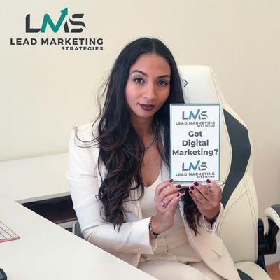 One of the Co-owners holding a sign inside of Lead Marketing Strategies in Commack, NY