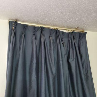 Old curtains hanging on some not all hooks