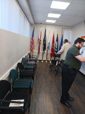 The waiting area inside with the US, FL, POW/MIA flags as well as flags of each branch of the military