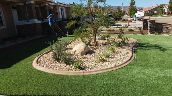 Landscape includes stamped concrete pathways, artificial turf and concrete curbing.