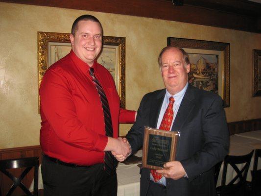 Chris Auffenberg right, presents Luke Munsell an award for achieving the Honor of Sales Leaders Club in the Chris Auffenberg Auto Group.