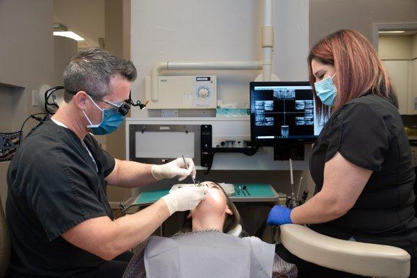 Dr. Simmon and the Dental Assistant treating a patient in Plano