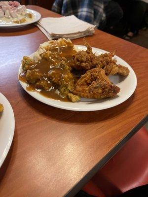 Fried chicken, dressing, mashed potatoes, and brown gravy.