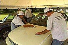 Our Skilled Technicians Working On A Claim Site Removing Overspray From Vehicles.